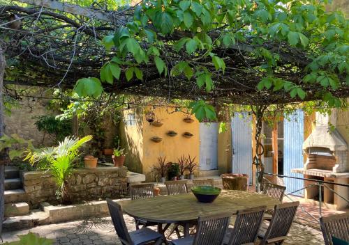 a patio with a table and chairs under a tree at Casa sardine in Cassis