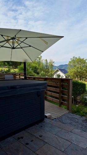 a white umbrella sitting on a wooden deck at Luxus Alpenparadies nahe Salzburg Sauna & Whirlpool in Adnet