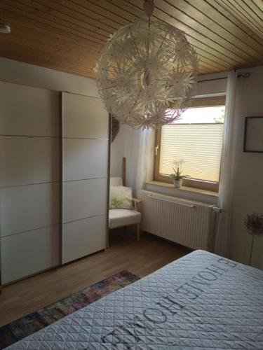 1 dormitorio con cama y lámpara de araña en Ferienwohnung Monteurwohnung Pusteblume, en Duderstadt