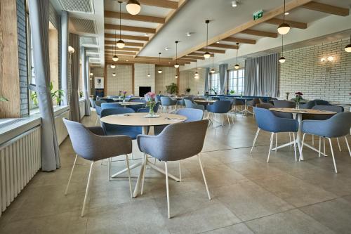 a restaurant with tables and chairs in a room at Apartments by Prague City Golf in Prague