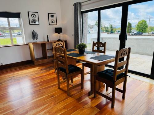 a dining room with a wooden table and chairs at De Búrca Cottage KERRY in Brackhill