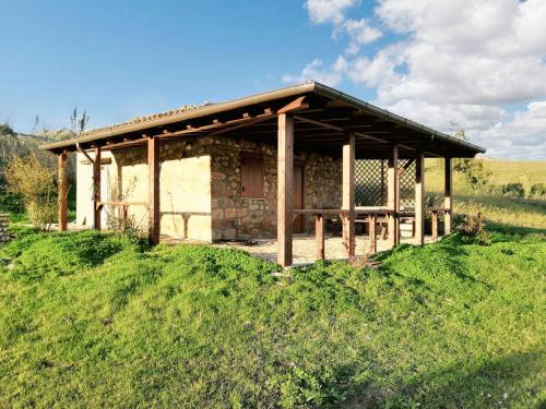 ein kleines Gebäude auf einem Hügel mit einem Grasfeld in der Unterkunft Studio with furnished garden at Lercara Friddi in Lercara Friddi
