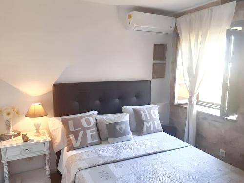 1 dormitorio con cama con almohadas y ventana en 2 bedrooms house with enclosed garden and wifi at Parada, en Parada