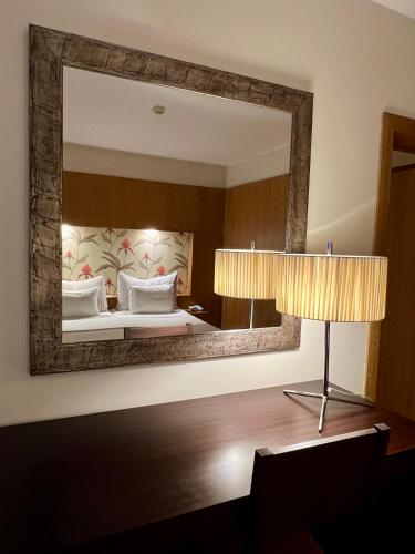 a bedroom with a large mirror and a bed at Apartamentos Turisticos Atlantida in Funchal