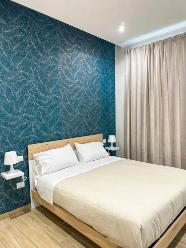 - une chambre avec un grand lit et un mur bleu dans l'établissement CasaMarì, à Torre del Greco