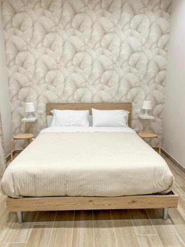 a bedroom with a large bed with a wall at CasaMarì in Torre del Greco