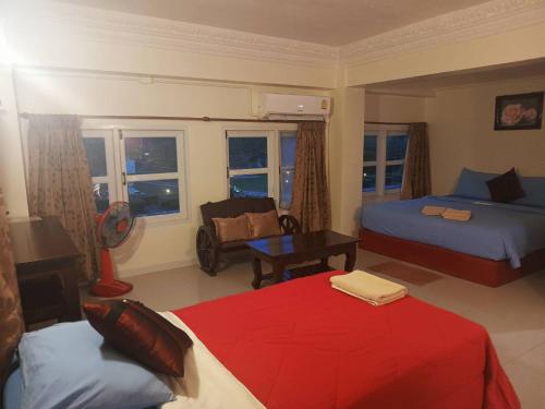 a bedroom with two beds and a couch and a chair at Anchalee Resort in Bang Saphan