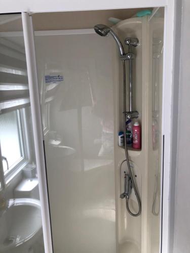 a shower in a bathroom next to a sink at Seabreeze, Utopia, Shorefield Country Park, Milford on Sea, Shorefield Road, SO41 0LH, United Kingdom in Milford on Sea