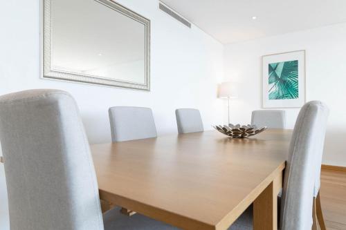a dining room with a wooden table and chairs at Akicity Jamor Selected in Cruz Quebrada