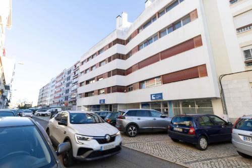 a parking lot with cars parked in front of a building at Akicity Jamor Selected in Cruz Quebrada