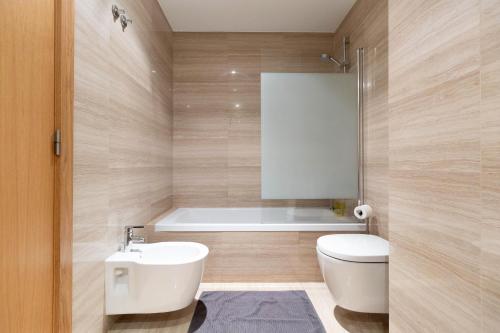 a bathroom with a tub and a toilet and a sink at Akicity Jamor Selected in Cruz Quebrada