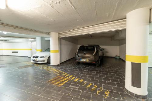a parking garage with two cars parked in it at Akicity Jamor Selected in Cruz Quebrada