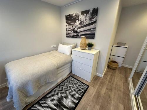 a bedroom with a bed with a dresser and a painting at MONTALTINO 4 - CON GARAJE OPCIONAL- Céntrico, Cuidado, Acogedor - Cerca playas in A Coruña