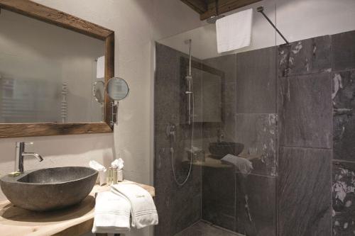 a bathroom with a sink and a shower at LANIG Hotel Resort&Spa - Wellness und Feinschmeckerhotel - family owned and managed in Oberjoch