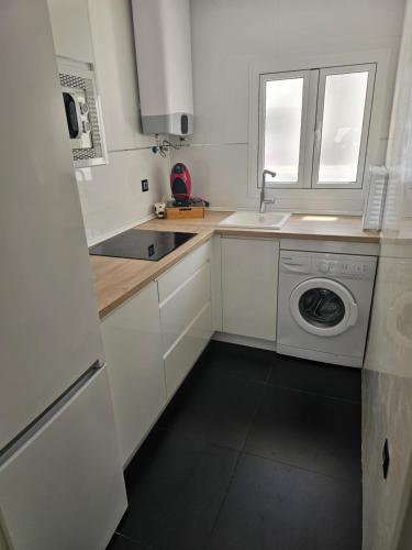 a white kitchen with a washing machine and a sink at Apartamento Luxury Home Huelva Zona centro in Huelva