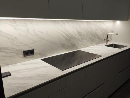 a marble counter top with a sink in a kitchen at Orchidee Apartment in Canedo