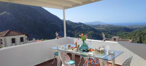a table on a balcony with a view of a mountain at Lappa Apartments in Aryiroúpolis