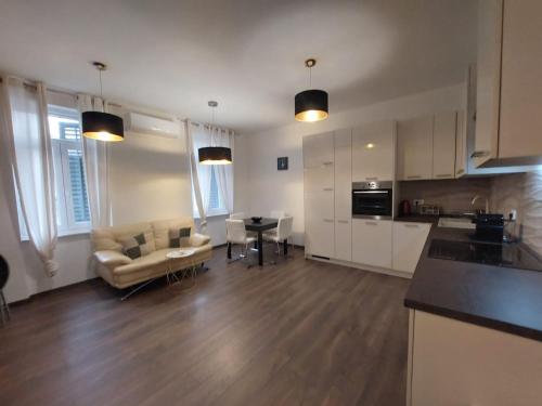 a kitchen and living room with a couch and a table at Apartman Lana in Rijeka