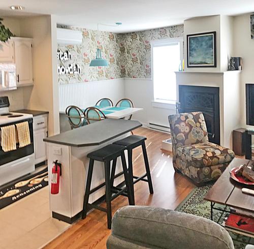 eine Küche und ein Wohnzimmer mit einem Tisch und Stühlen in der Unterkunft The John Randall House in Provincetown