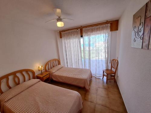 a hotel room with two beds and a window at Apartamentos Góndolas V.v. in La Manga del Mar Menor