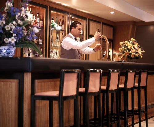 a man standing behind a bar with a saxophone at Aparthotel VIP Executive Suites do Marquês in Lisbon