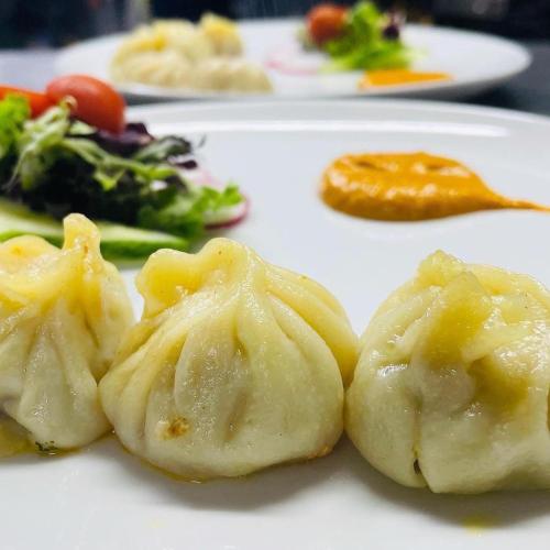 a white plate with dumplings and vegetables on it at woodcock inn in Felbridge