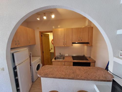uma cozinha com um arco no meio em Apartamentos Góndolas V.v. em La Manga del Mar Menor