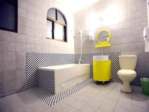 een badkamer met een wastafel, een bad en een toilet bij Anshun Hotel in Taichung