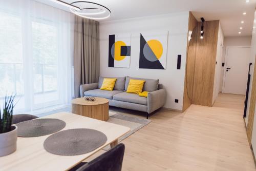 a living room with a couch and a table at Nice River Apartment in Ostróda
