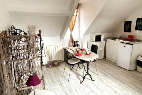 una piccola cucina con tavolo e sedie in camera di Le Cocon rouge - studio en plein centre historique a Lamballe