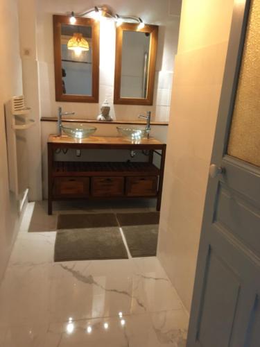 une salle de bain avec deux lavabos et deux miroirs dans l'établissement appartement 3 chambres biarritz aguilera, à Biarritz