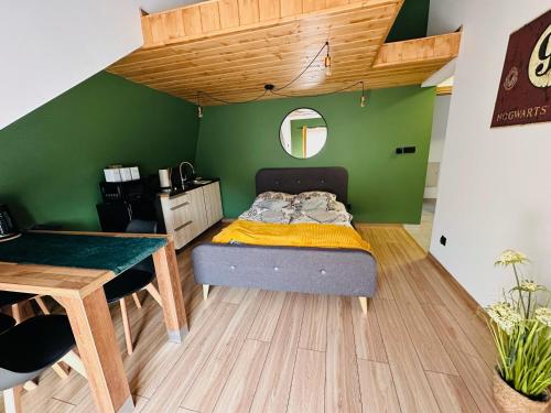 uma cama num quarto com uma parede verde em U Babci na strychu em Zakopane