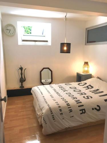 een slaapkamer met een bed en een raam en een klok bij appartement 3 chambres biarritz aguilera in Biarritz