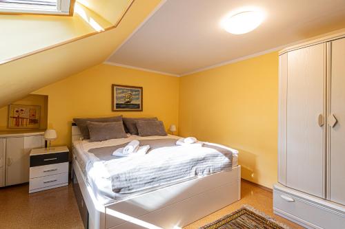 a bedroom with a large bed with yellow walls at 2HomeRent Lento Międzyzdroje in Międzyzdroje