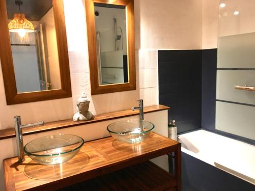 - une salle de bains avec 2 bols en verre sur un comptoir en bois dans l'établissement appartement 3 chambres biarritz aguilera, à Biarritz
