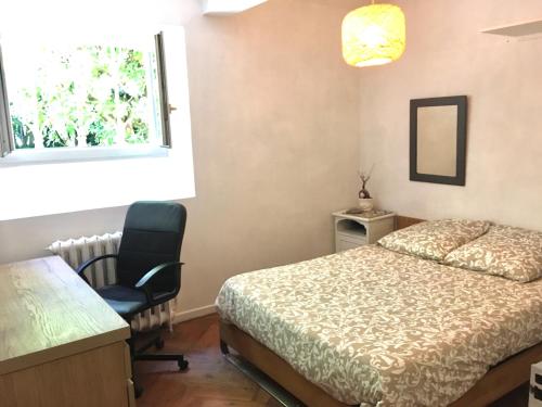 een slaapkamer met een bed, een stoel en een raam bij appartement 3 chambres biarritz aguilera in Biarritz