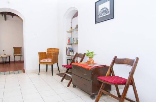 une chambre avec des chaises et une vieille valise dans l'établissement Hotel Niyati Guest House, à Vieux-Goa