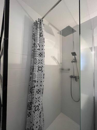 une salle de bain avec une douche avec un rideau de douche dans l'établissement Charmant T2 à 200m plage, à Sète