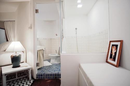 a bathroom with a tub and a sink and a toilet at Vimala Suites in Bangkok