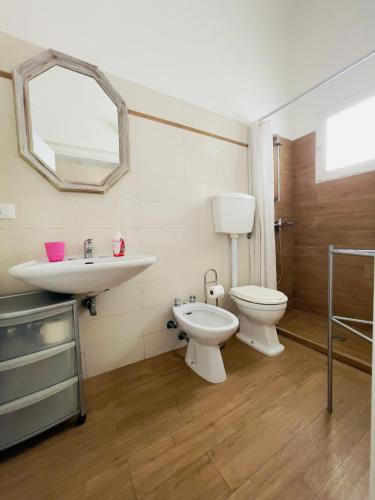a bathroom with a sink and a toilet and a mirror at Salento apartment in Torre Lapillo