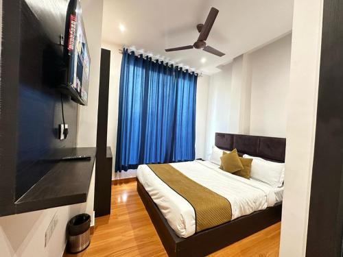 um quarto com uma cama com cortinas azuis e uma televisão em Hotel The Restu And Restaurant 300 Meter From Golden Temple em Amritsar