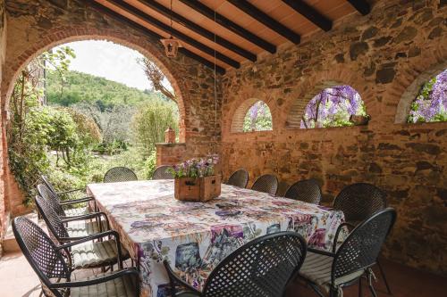 comedor con mesa, sillas y ventanas en Podere L'Erbolario, stylish villa with private pool and olive garden., en Scrofiano