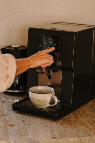 a woman is pointing at a coffee cup at Boho Sfera in Kopalino