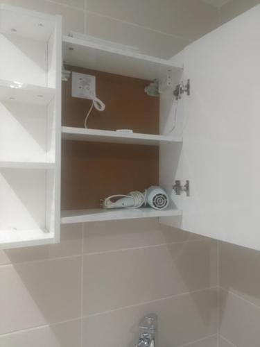ein Badezimmer mit einem Waschbecken und einem Schrank mit einem Telefon in der Unterkunft Studio à 15 min du stade de France et de la gare du Nord in Sarcelles