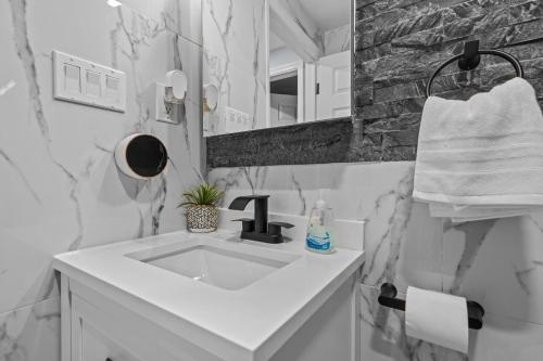 ein weißes Badezimmer mit einem Waschbecken und einem Spiegel in der Unterkunft The Luxurious loft in Newark