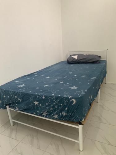 a bed with a blue sheet with stars on it at Homestay muslim adawiyah Nilai in Nilai