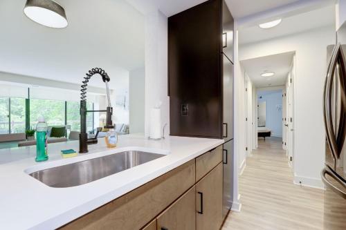 2BR Executive Apartment with Spacious Layout في أرلينغتون: مطبخ مع حوض ومرآة كبيرة
