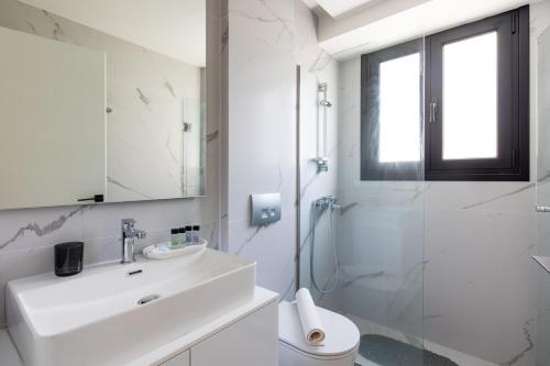 y baño blanco con lavabo y ducha. en Athens Sea Side Escape en Vari