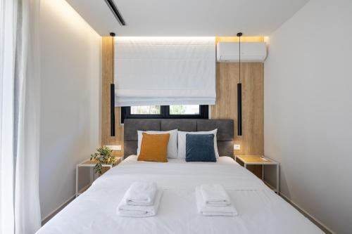 1 dormitorio con 1 cama blanca grande y 2 almohadas en Athens Sea Side Escape en Vari