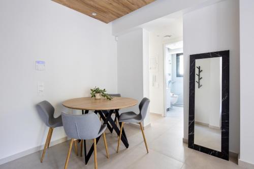 a dining room with a table and chairs and a mirror at Athens Sea Side Escape in Vari